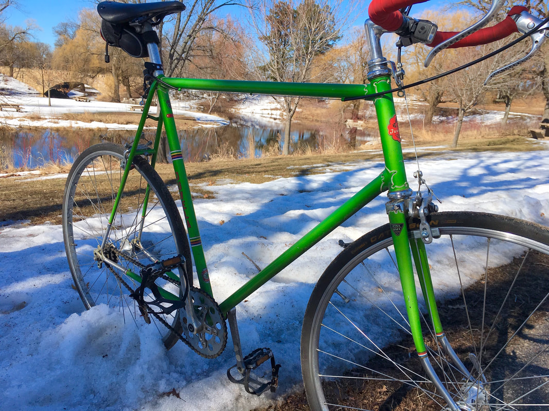 a green fixie bicycle in the snow